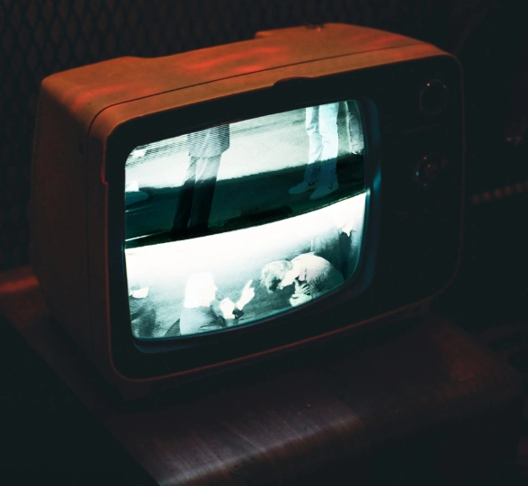 A CRT television displaying a static-filled image of televangelist Benny Hinn.